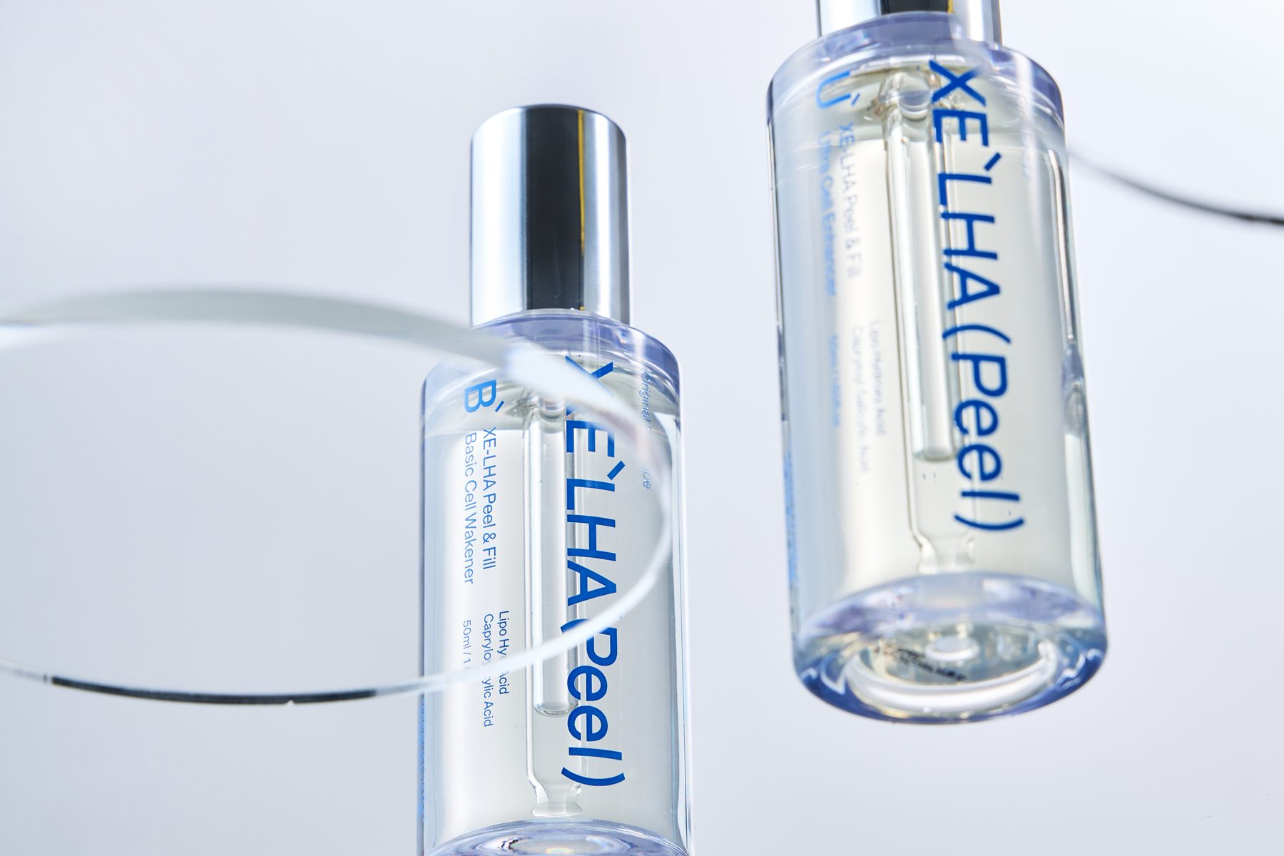 Two XE'LHA Peel bottles floating between glass discs