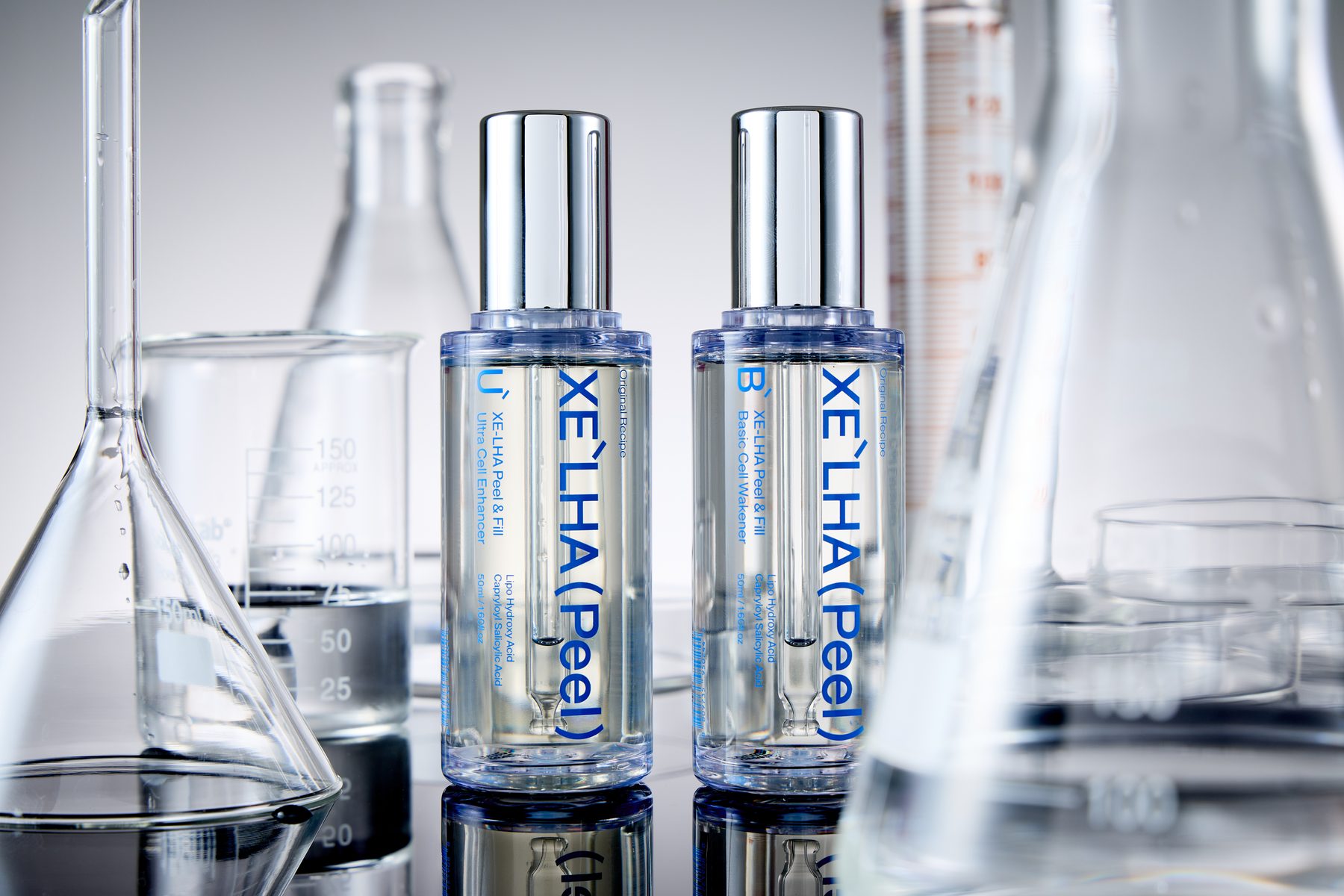 Two XE'LHA Peel bottles among laboratory glassware